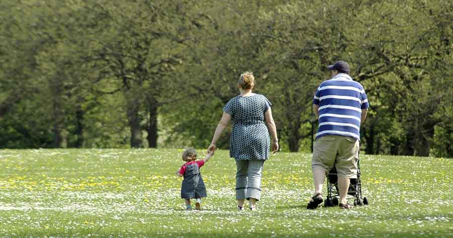 Young family walking in a park.