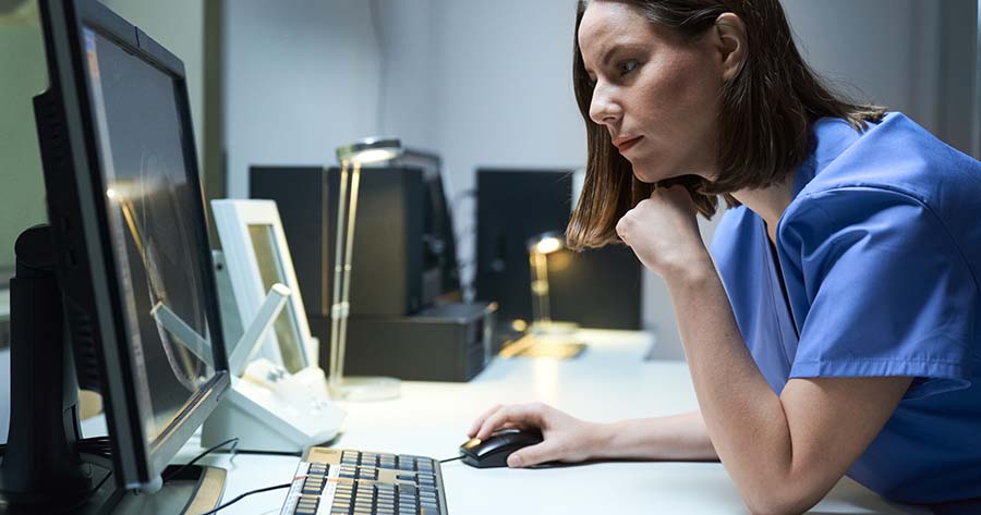 Nurse concentrating at screen.
