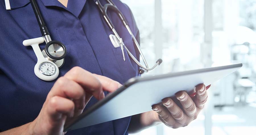 Nurse using digital tablet on ward