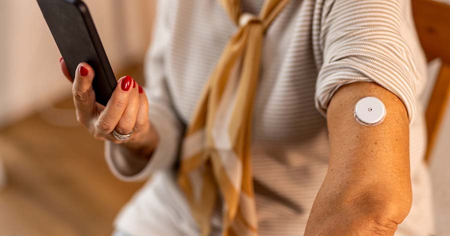 Woman using continuous glucose monitoring system