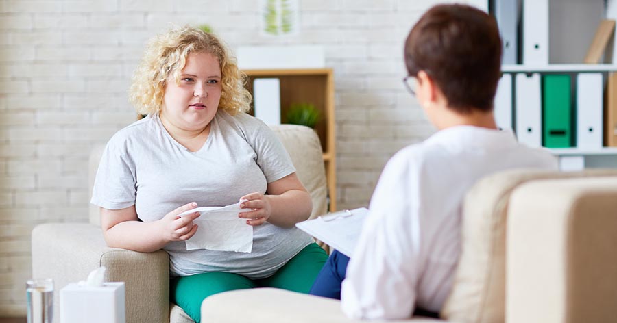 Teenaged woman talking to counsellor.