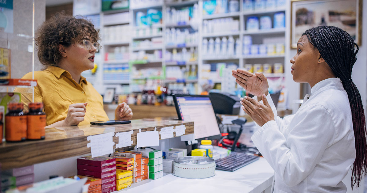 Pharmacist talks to customer